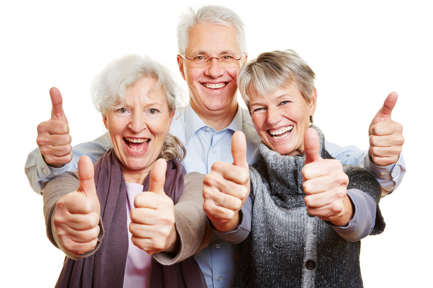 Three happy senior people holding thumbs up